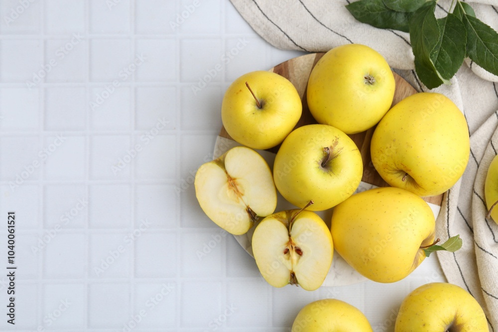 Sticker Fresh ripe yellow apples and leaves on white tiled table, flat lay. Space for text