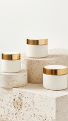 Elegant Trio of Minimalist Cream Jars with Luxurious Gold Accents on Stacked Stone Pedestals