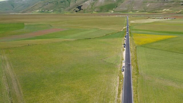 Flying over a road in the countryside. Castelluccio di Norcia plateau, Italy