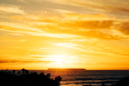 Sun setting behind Lady Julia Percy Island viewed across the water from The Crags