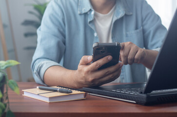 Men's hands on the table use mobile phones, technology, communications, the Internet.