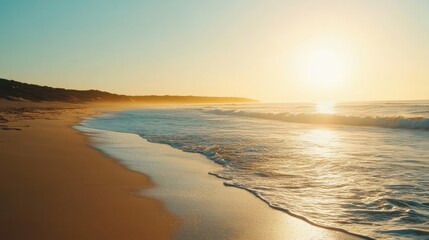 Fototapeta premium Golden hour beach with waves gently washing the shore, soft sunlight glowing over the horizon as the day peacefully ends