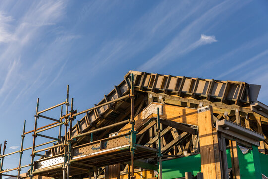 point of a roof of a house getting built on a sunny day