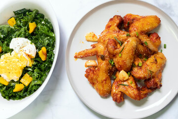 A delicious plate of crispy chicken wings paired with a fresh salad for a perfect meal.