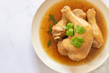 Delicious chicken in savory broth garnished with fresh herbs, perfect for a hearty meal or comforting dish.