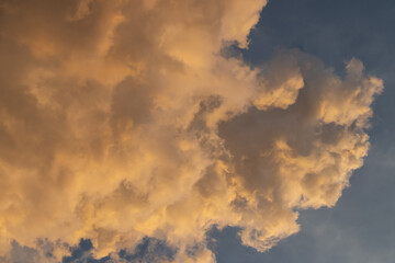 Soft golden clouds in a blue sky create a tranquil and serene atmosphere, perfect for peaceful landscapes or nature themes.