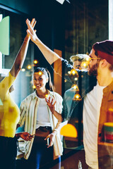 Happy multiracial crew of colleagues satisfied of completing project together giving high five, young team on millennial students celebrating success  in coworking office, team building concept © BullRun