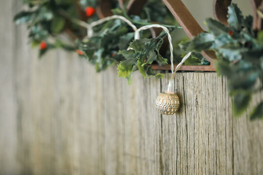 Mistletoe and delicate Christmas lights strewn along rustic wooden seat