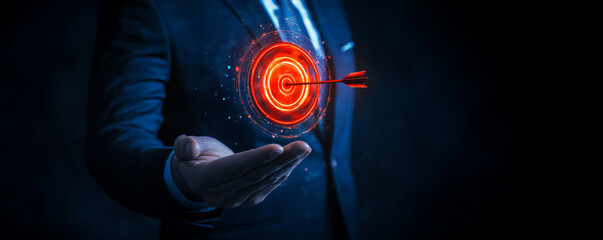 Business professional holding a glowing red digital target with an arrow in the center, symbolizing focus, precision, and success in business strategy and goals