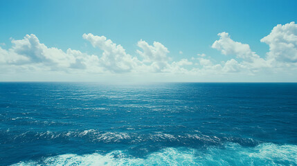 Fototapeta premium serene ocean view with clear blue waters and fluffy white clouds under bright sky creates peaceful atmosphere. endless horizon invites tranquility and reflection