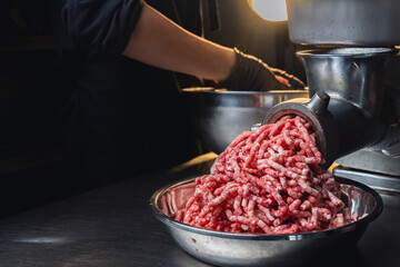 Process of fresh meat grinding in the kitchen with modern electric grinder, closed up