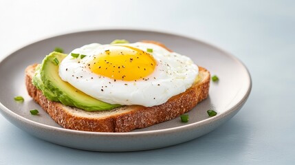 Delicious avocado toast topped with a sunny-side-up egg