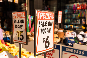 special sale signs in golden sunlight in front of a shop