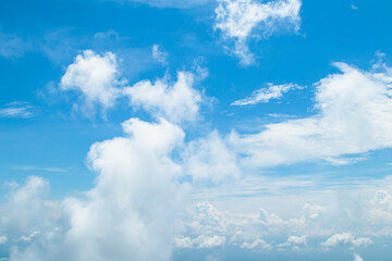 Morning view over white puffy clouds with blue sky on horizon.