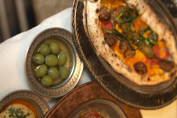Olives and pizza on the table in the restaurant