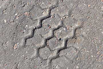 Melt asphalt imprint. Tyre mark texture. Tire track on the road background. Highway damaged with sunlight heat. Grunge street background. High heat summer asphalt. Destroyed damaged road.