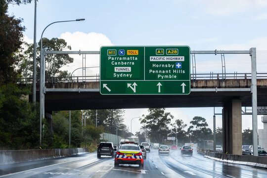 Highway patrol police vehicle following cars on wet road towards Parramatta Sydney
