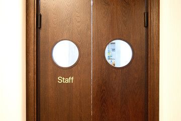 Wooden staff door with round windows. Entrance to employee area