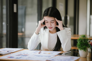 Asian businesswoman stressed about her projects, planning and thinking of new strategies at the office.