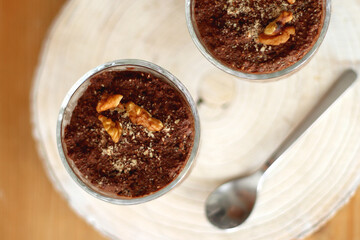 Two bowls of chia seed, chocolate and orange pudding. Healthy snack, wooden background. Top view.
