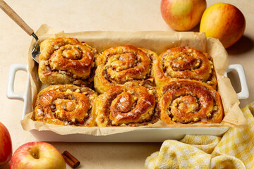 Homemade baked Rolls Buns with apples, walnut and cinnamon, glazed. Beige table background.
