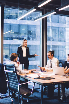 Professional financial experts collaborating during brainstorming meeting listening information from clever female director, businesswoman providing information to corporate workers of company
