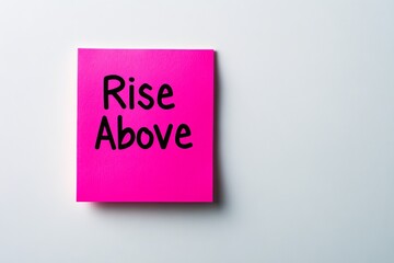 A pink sticky note showcases the motivational phrase 'Rise Above,' promoting resilience and self-empowerment with its vibrant color and impactful design message.