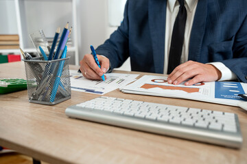 Fototapeta premium businessman hand working with computer and accounting annual report with business document