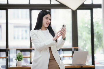 Fototapeta premium Portrait of a young businesswoman working on a laptop in an office