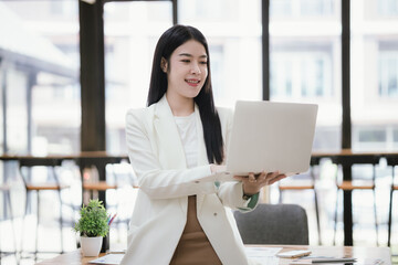 Portrait of a young businesswoman working on a laptop in an office