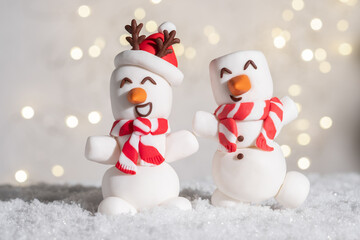 Happy funny marshmallow snowmans on snow