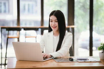 Portrait of a young businesswoman working on a laptop in an office