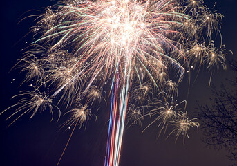 Bright fireworks explode in the night sky, creating a colorful and dazzling display of light and...