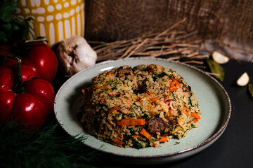 Spanish rice, uzbek pilaf hot dish with meat and vegetables, rustic table kitchen decoration with ingredients