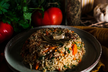 Spanish rice, uzbek pilaf hot dish with meat and vegetables, rustic table kitchen decoration with...