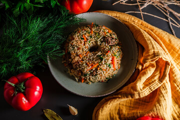Spanish rice, uzbek pilaf hot dish with meat and vegetables, rustic table kitchen decoration with...