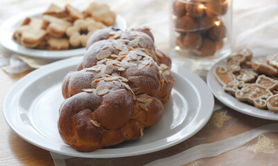 Traditional Czech and Slovak Christmas sweet plaited bread called vanocka (in Slovak vianocka), Linzer and gingerbread cookies in the background. Handmade Christmas pastry on a festively set table.