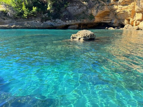 Turquoise clear sea in hidden rocky cove 