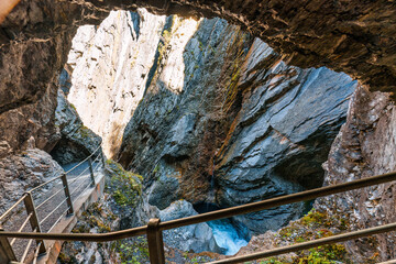 Natural limestone cave with stream flowing in Rosenlaui glacier gorge