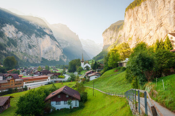 Scenic view of Lauterbrunnen mountain village with famous church and Staubbach Falls in the morning at Switzerland