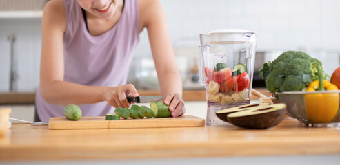 Young Healthy Woman Preparing Fresh Juice in Modern Kitchen with Fresh Vegetables and Fruits