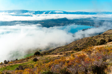 Scenic foggy mountain view from summit of Roys Peak and Lake Wanaka in autumn at New Zealand