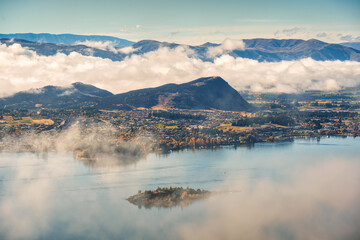 Scenic foggy mountain from summit of Roys Peak with Lake Wanaka in the morning at New Zealand