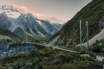 View of suspension bridge with mountain range on Hooker Valley Track in national park at New Zealand