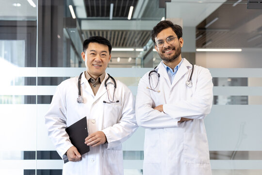 Two smiling doctors in lab coats stand confidently, representing professionalism and teamwork in medical facility. Keywords: doctors, healthcare, teamwork, medical, professional, collaboration.
