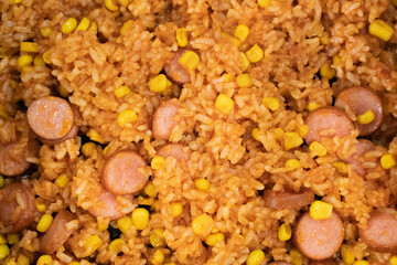 Delicious and easy to prepare homemade dish. Fried rice with corn and chopped sausages in tomato sauce or ketchup. Cooking tasty food