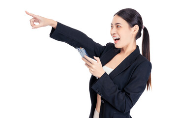 Excited Young Asian business woman points to copy space while holding a smartphone, conveying a sense of excitement and discovery.