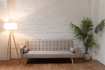 Couch over white brick wall in empty living room with copy space. High quality photo