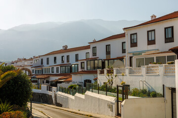 Traditional architecture Canary Islands, Spain. Typical Canarian white house with brown roof in early morning. Building near Puerto de la Cruz, Tenerife. Amazing landscape with mountains.