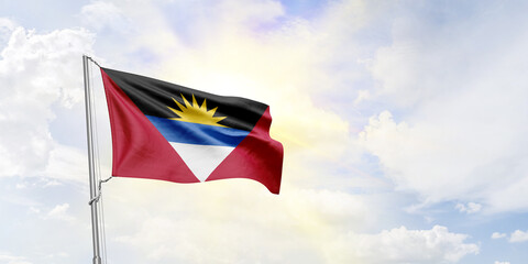 Antigua and Barbuda flag waving on sky background. 3D Rendering